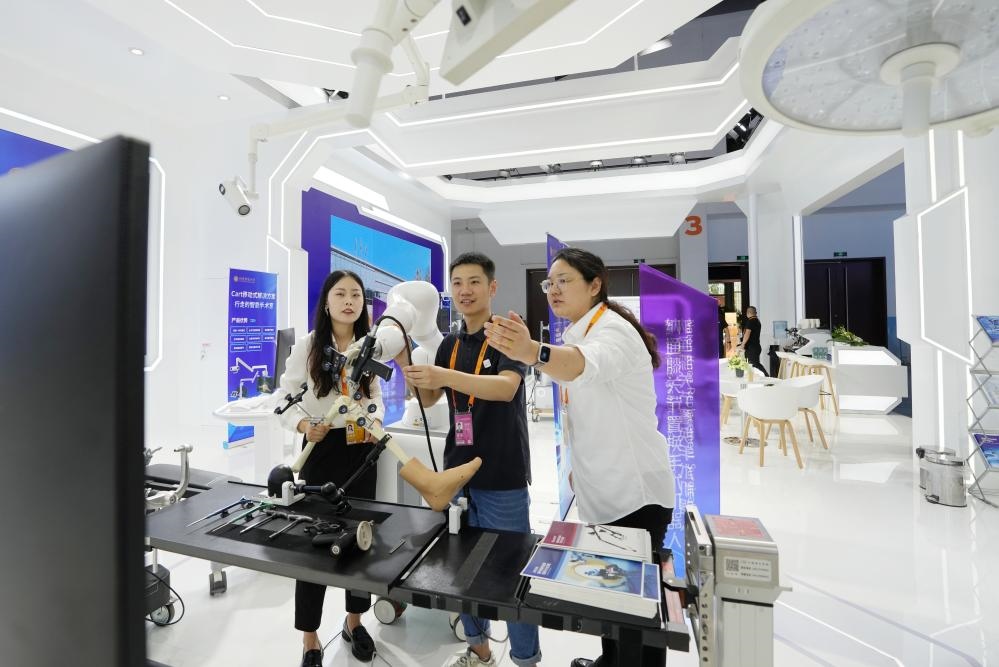 9月11日，一位媒體記者（中）在2024年服貿(mào)會(huì)國(guó)家會(huì)議中心會(huì)場(chǎng)體驗(yàn)北京納通科技集團(tuán)有限公司的膝關(guān)節(jié)置換手術(shù)機(jī)器人。新華社記者鞠煥宗 攝