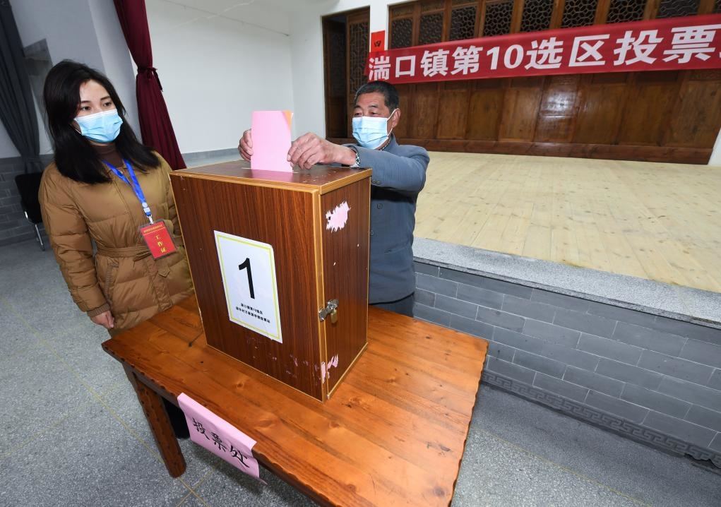 2021年12月14日，在浙江省杭州市臨安區(qū)湍口鎮(zhèn)迎豐村的基層投票點，村民在參加投票，村級監(jiān)察聯(lián)絡員監(jiān)票。新華社記者 徐昱 攝