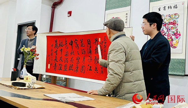 旅秘書法家向現(xiàn)場(chǎng)觀眾展示書法作品。人民網(wǎng)記者 宋亦然攝