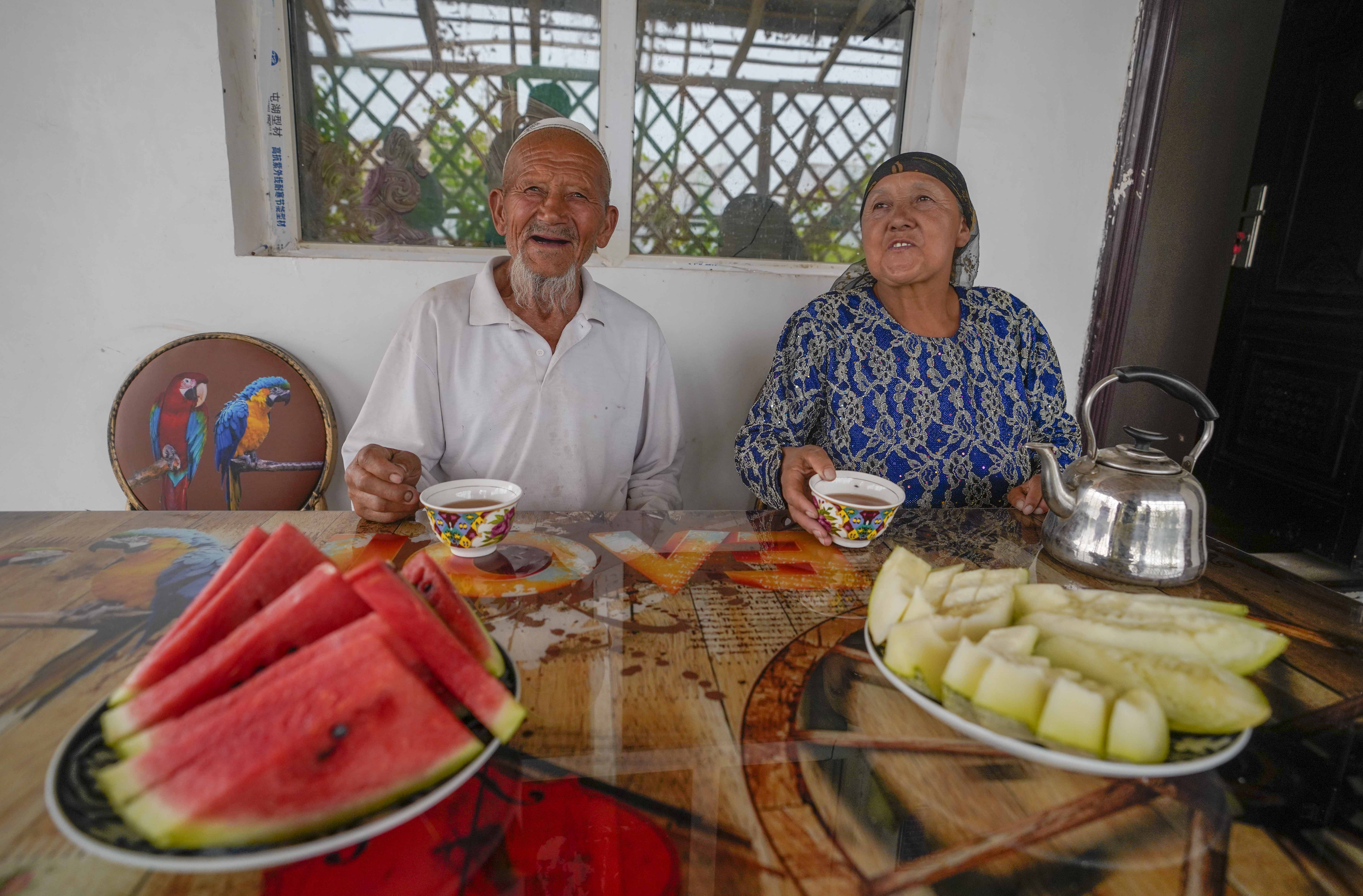 在新疆喀什地區(qū)伽師縣江巴孜鄉(xiāng)依帕克其村57號(hào)，80歲的維吾爾族老人伊米提·艾山（左）在自家庭院中（2020年6月8日攝）。