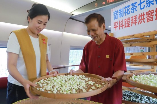 10月1日，福州市茉莉花茶窨制工藝代表性傳承人張子建與旅客在G1634次列車上制作茉莉花茶。新華社記者周義 攝