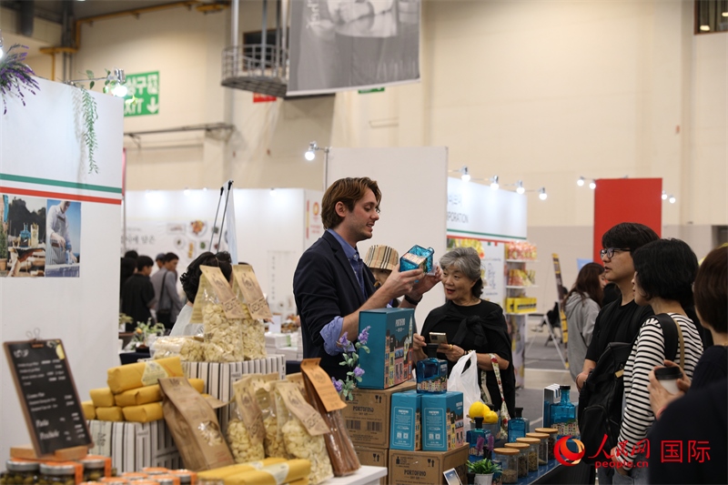 當?shù)貢r間10月5日，在第21屆釜山國際美食博覽會上，意大利展商向參觀者們介紹的意大利食品。人民網(wǎng)記者 莽九晨攝
