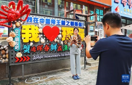 9月21日，游客在吉林省琿春市一處帝王蟹元素主題裝飾前拍照留念。新華社發(fā)