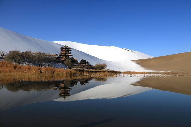 鳴沙山月牙泉景區(qū)雪景。敦煌市委宣傳部供圖，張曉亮攝