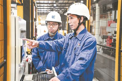 在廣西柳工機(jī)械股份有限公司生產(chǎn)車間內(nèi)，一名高級(jí)技師（右）給徒弟講解數(shù)控設(shè)備操作細(xì)節(jié)。新華社記者 曹祎銘攝