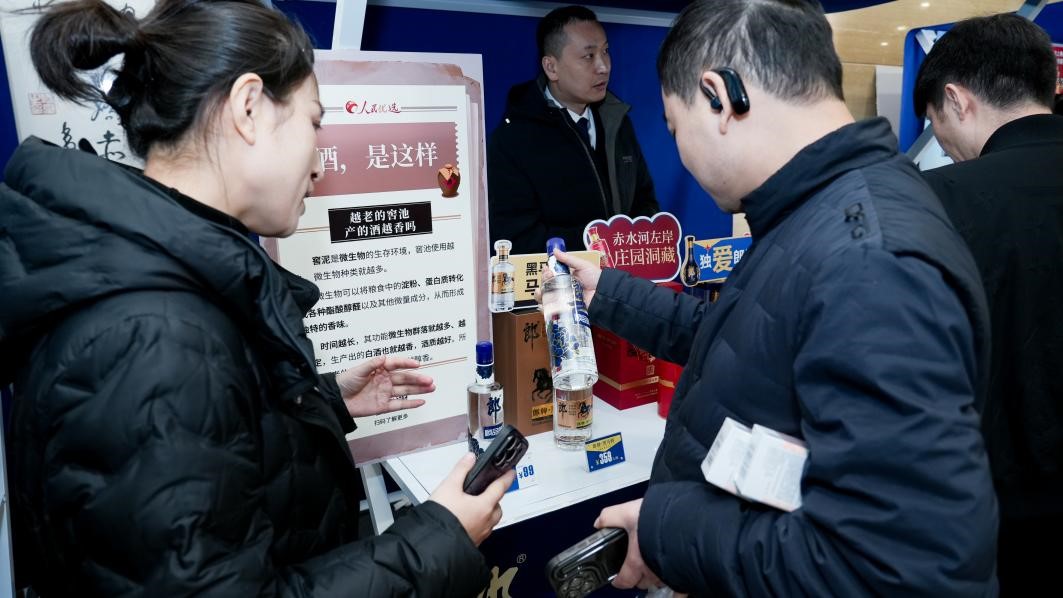 白酒展位負責人在為嘉賓介紹。張新攝