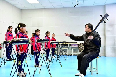 圖為12月30日，在惠民縣胡集鎮(zhèn)第一小學(xué)，老師指導(dǎo)學(xué)生學(xué)習(xí)西河大鼓。新華社記者 郭緒雷攝