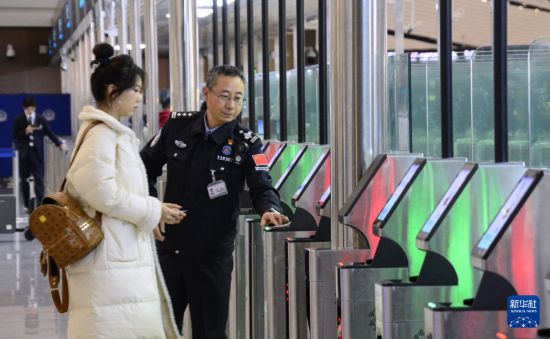 1月2日，大興機(jī)場邊檢站警察指導(dǎo)旅客使用自助出境設(shè)備。新華社記者 李欣 攝