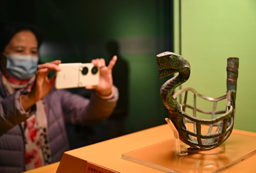 1月14日，觀眾在上海博物館蛇年迎春展拍攝展品蛇綱網(wǎng)狀銅器。新華社發(fā)（陳浩明攝）