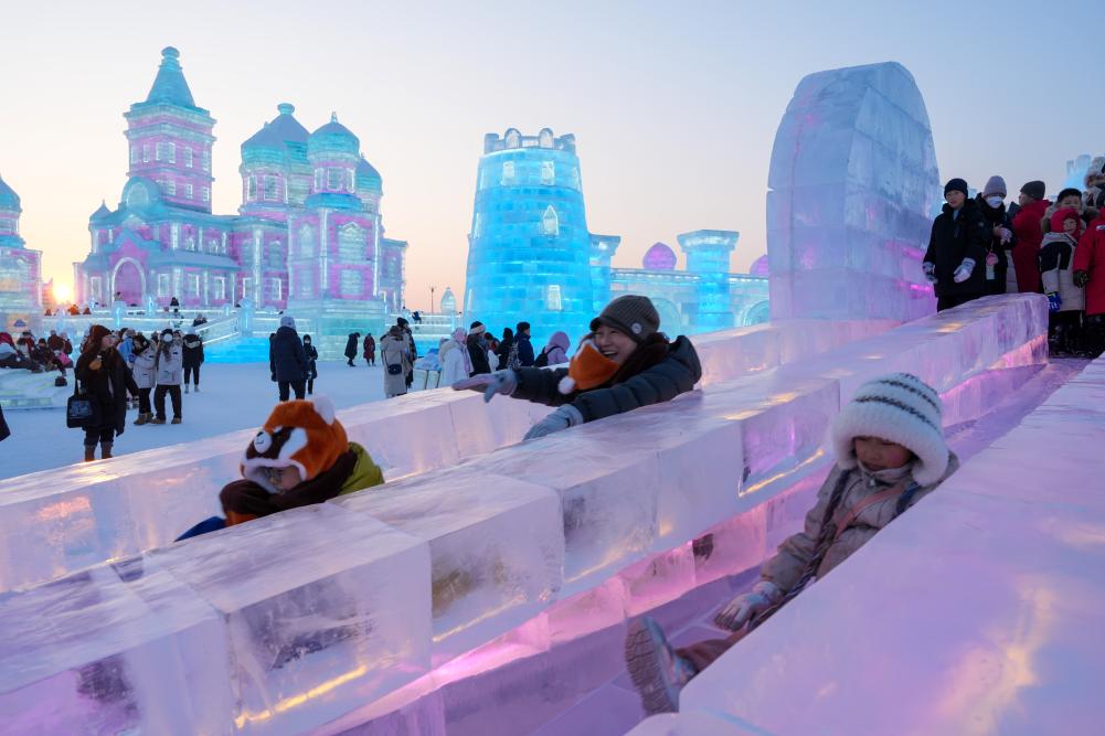 游客在哈爾濱冰雪大世界園區(qū)內(nèi)體驗(yàn)冰滑梯。新華社發(fā)