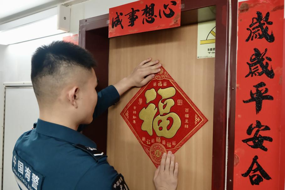 1月27日，在中國(guó)海警海鷗艦上，執(zhí)法員貼春聯(lián)福字慶祝農(nóng)歷春節(jié)。