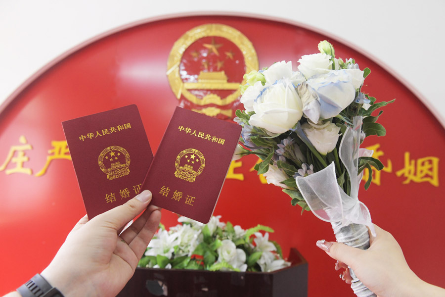 2024年8月10日，一對新人在河北石家莊新樂市民政局婚姻登記處領(lǐng)取結(jié)婚證后拍照留念。新華社發(fā)（賈敏杰攝）