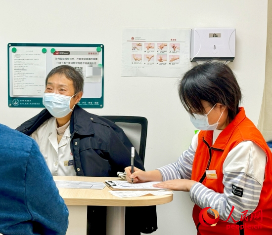 秦苑（中）接診患者。人民網(wǎng)記者 金慧慧攝