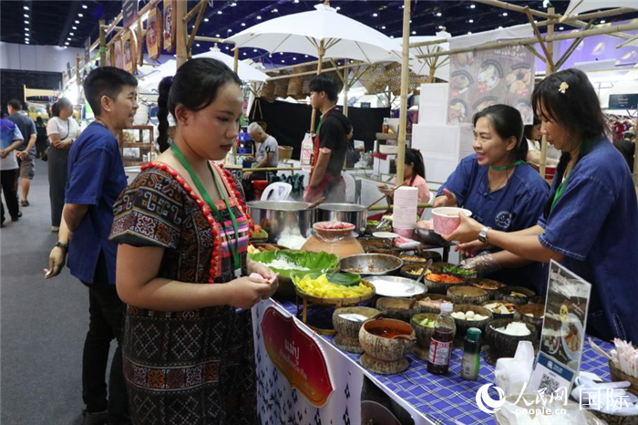 游客在攤位前購買特色美食。朱瀟逸攝