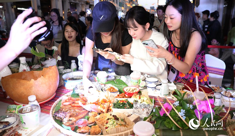 游客拍照打卡體驗(yàn)長(zhǎng)桌宴。人民網(wǎng)記者 符武平攝