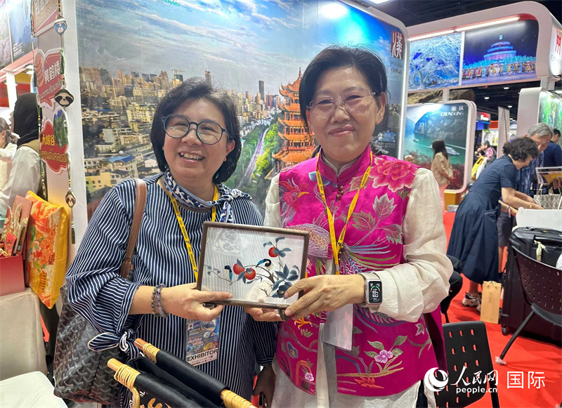 中國“大冶刺繡”傳承人劉小紅（右）參加泰國國際旅游展，向觀眾介紹中國非遺刺繡針法。人民網(wǎng)記者 簡(jiǎn)承淵攝