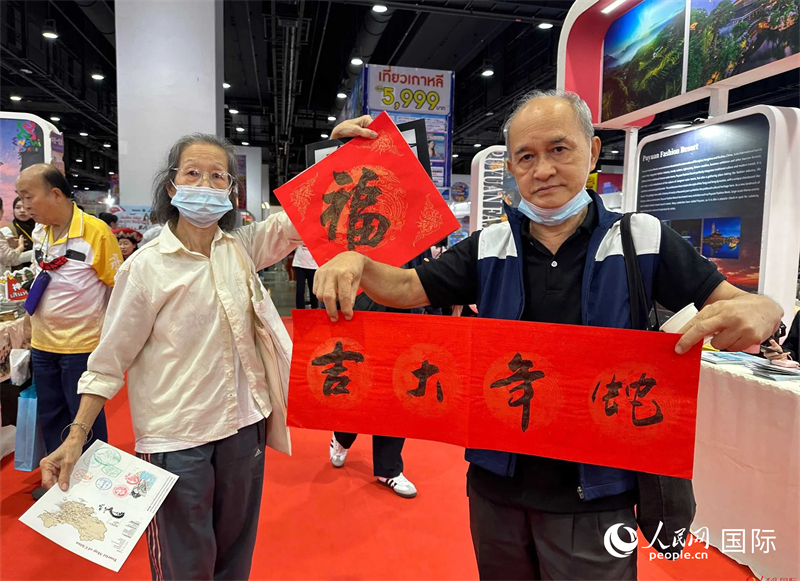 2025蛇年春節(jié)，泰國市民展示他們領(lǐng)到的華人手寫春聯(lián)。人民網(wǎng)記者 簡(jiǎn)承淵攝