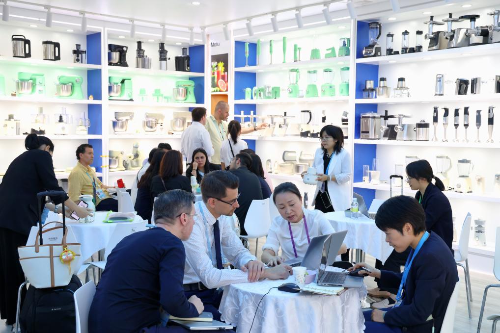 4月15日，在第137屆廣交會開幕當天，海外客商在一家電器公司的展區(qū)洽談。 新華社記者 劉大偉 攝