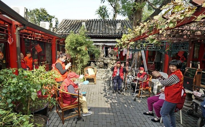 2024年10月12日，鐘樓灣胡同的老年人在社區(qū)內(nèi)的四合院養(yǎng)老驛站休閑。2017年起，北京市先后開展了兩輪背街小巷環(huán)境整治提升行動(dòng)，完整保留了中軸線生活建筑群的歷史信息，并根據(jù)居民的生活和居住方式進(jìn)行適配化的更新和改造，極大地改善了生活環(huán)境。2023年鐘樓灣胡同被評(píng)為“北京最美街巷”。