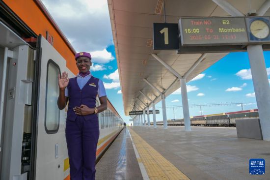 5月31日，在蒙內(nèi)鐵路內(nèi)羅畢站，一名乘務(wù)員在即將開往蒙巴薩的E2次列車旁等候乘客。新華社記者 楊光 攝