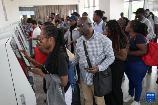 5月31日，在蒙內(nèi)鐵路內(nèi)羅畢站，乘客在自助取票機(jī)前排隊(duì)取票。新華社記者 楊光 攝