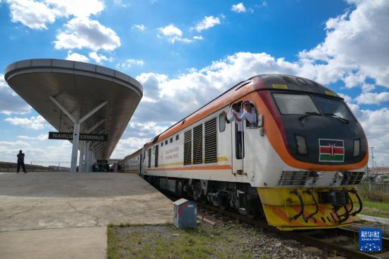 5月31日，在蒙內(nèi)鐵路內(nèi)羅畢站，機(jī)車駕駛員蔣立平（右）和博爾在即將開往蒙巴薩的E2次列車上揮手致意。新華社記者 楊光 攝